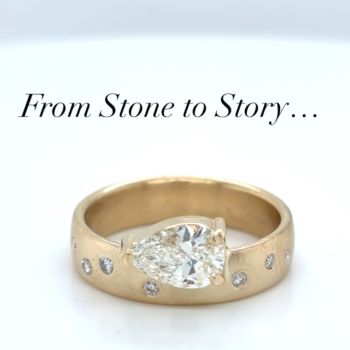 Close up of a gold ring with a pear shaped diamond