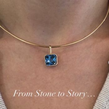 Close up of a woman's necklace with blue stone